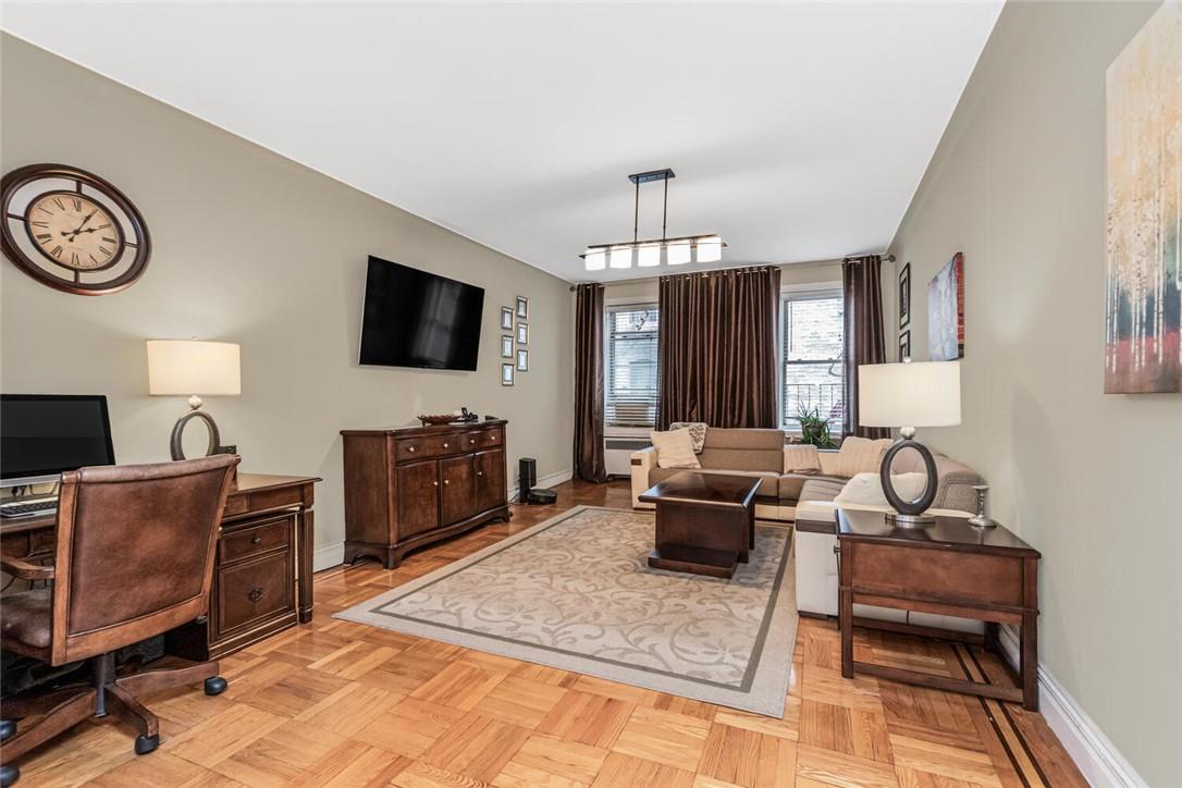 a living room with furniture a flat screen tv and kitchen view