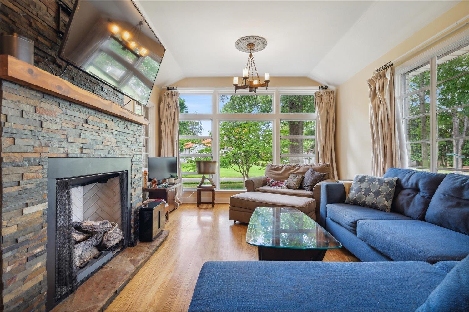 a living room with furniture fireplace and large windows