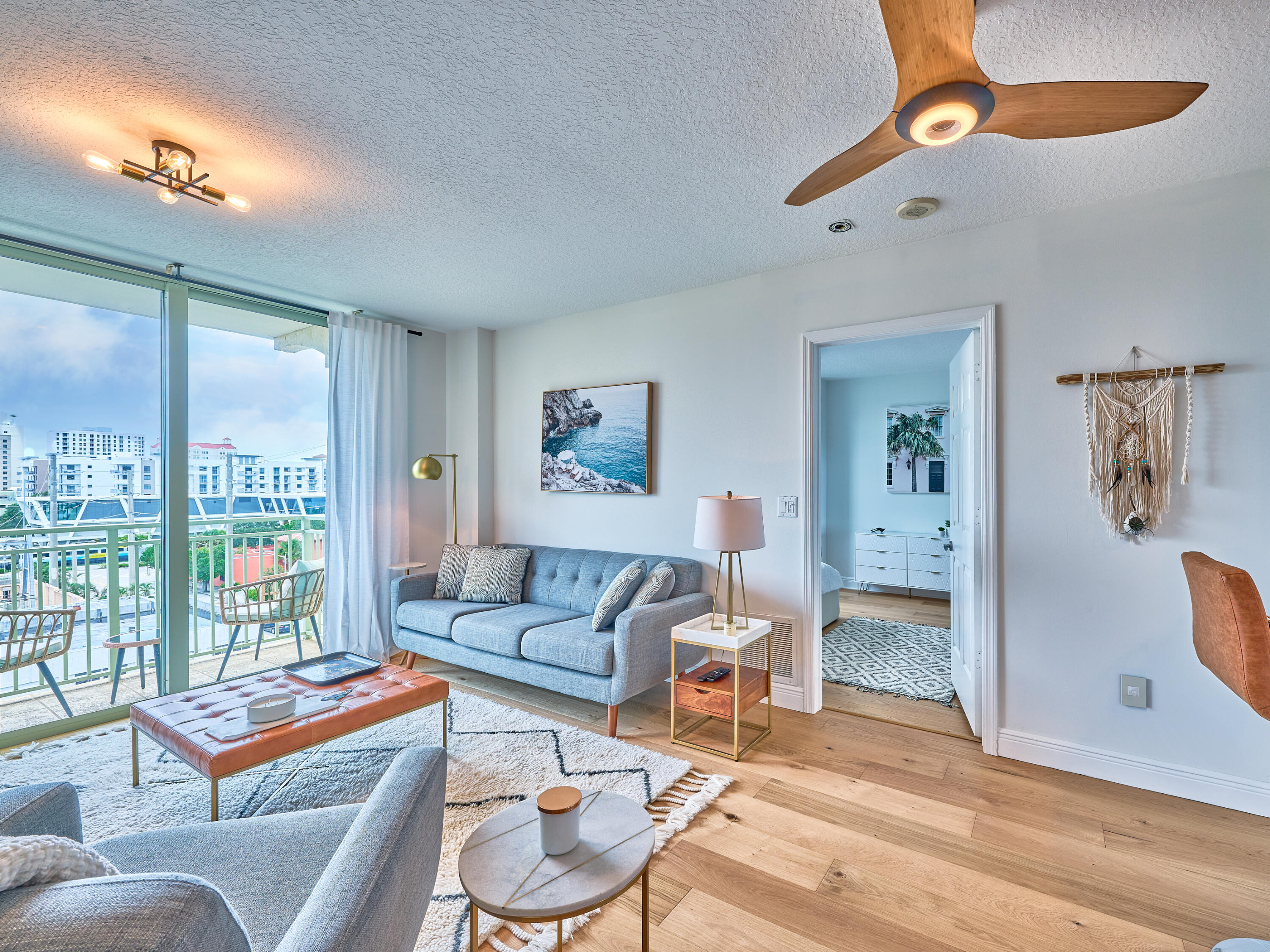 a living room with furniture a rug and a floor to ceiling window