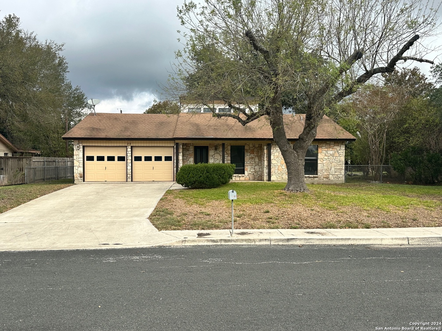 a view of a house with a yard and large tree