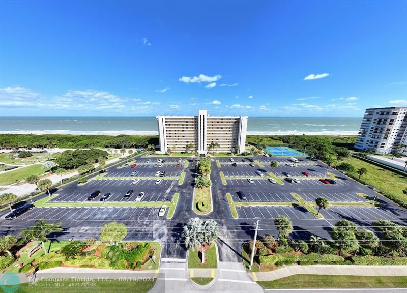 an aerial view of residential houses with outdoor space and ocean view