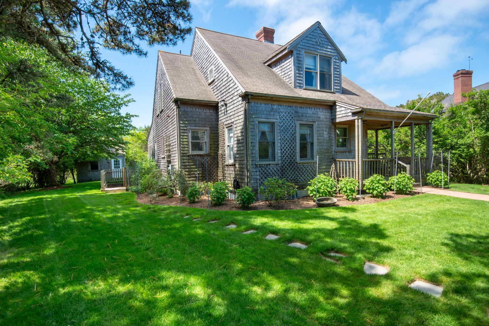 a front view of a house with a yard and trees