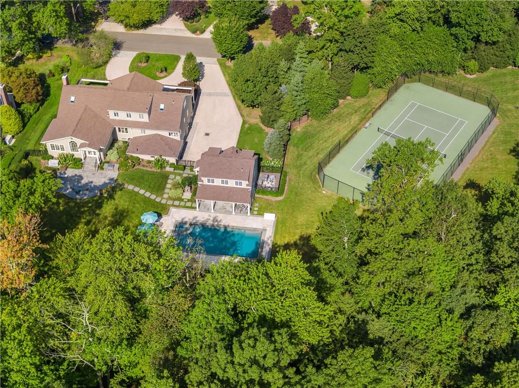 an aerial view of residential house with outdoor space and trees all around