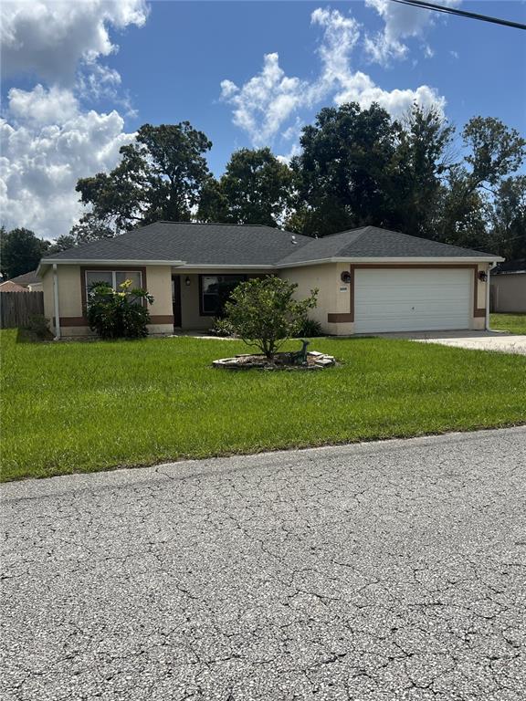 front view of a house with a yard and a garage