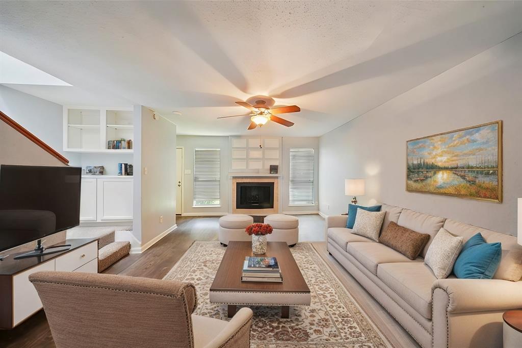 This beautifully staged living room offers a warm and inviting space, featuring elegant furnishings, a cozy fireplace, and abundant natural light—perfect for relaxing and entertaining.