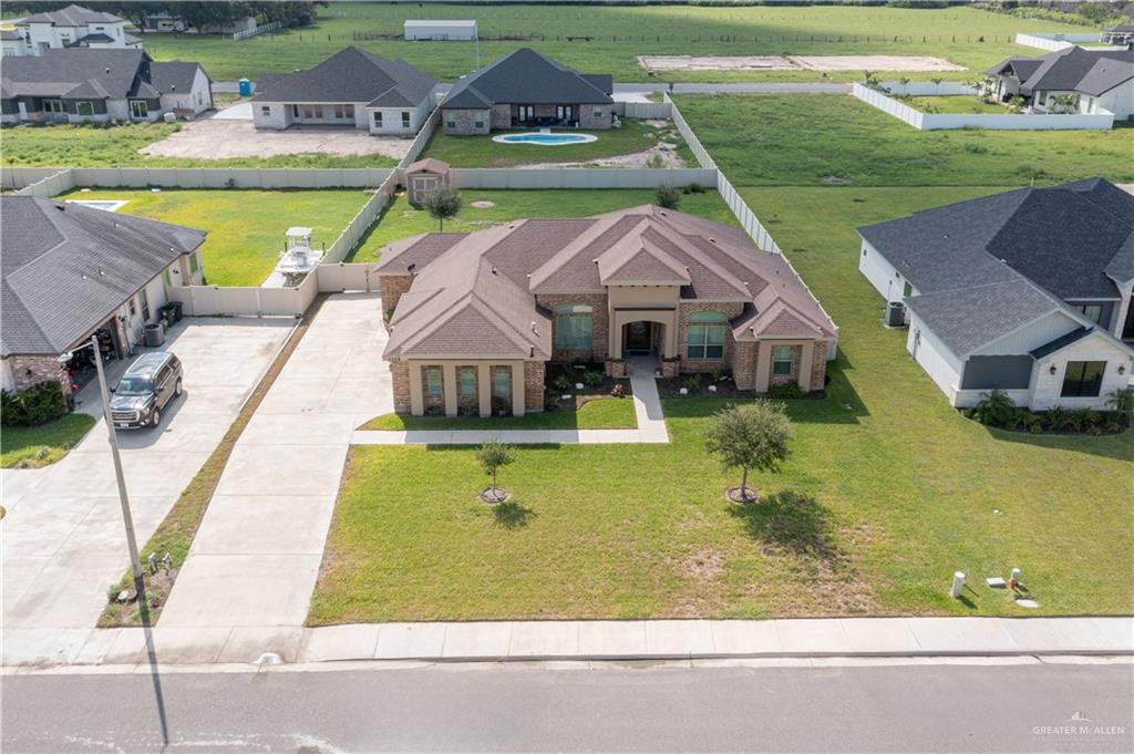 an aerial view of a house with swimming pool and a yard