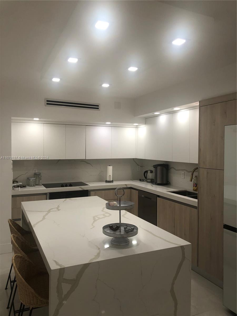 a kitchen with kitchen island a sink stainless steel appliances and window