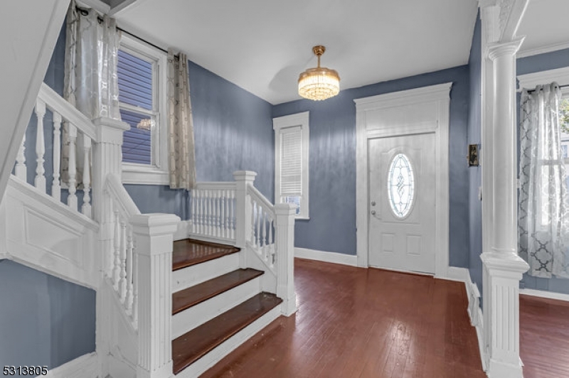 a view of a livingroom with wooden floor and staircase