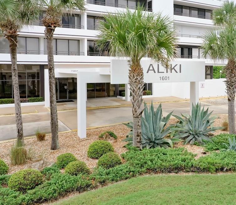 a front view of a multi story residential apartment building with a yard