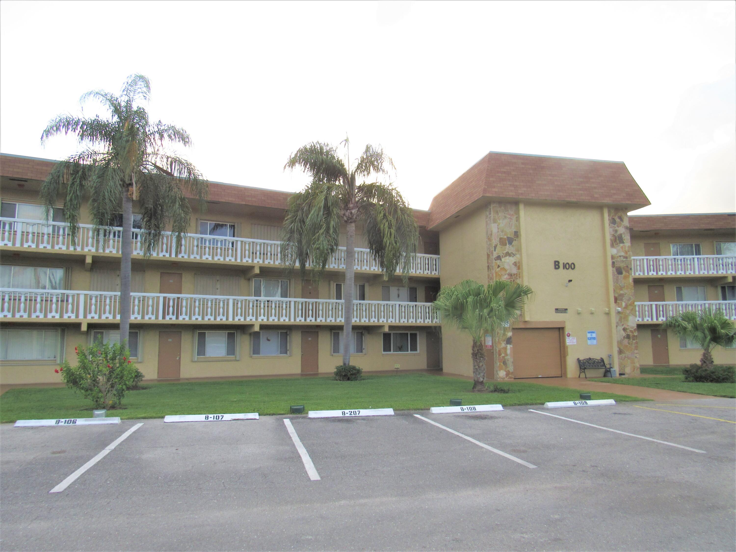 a view of a big building with a big yard and large trees