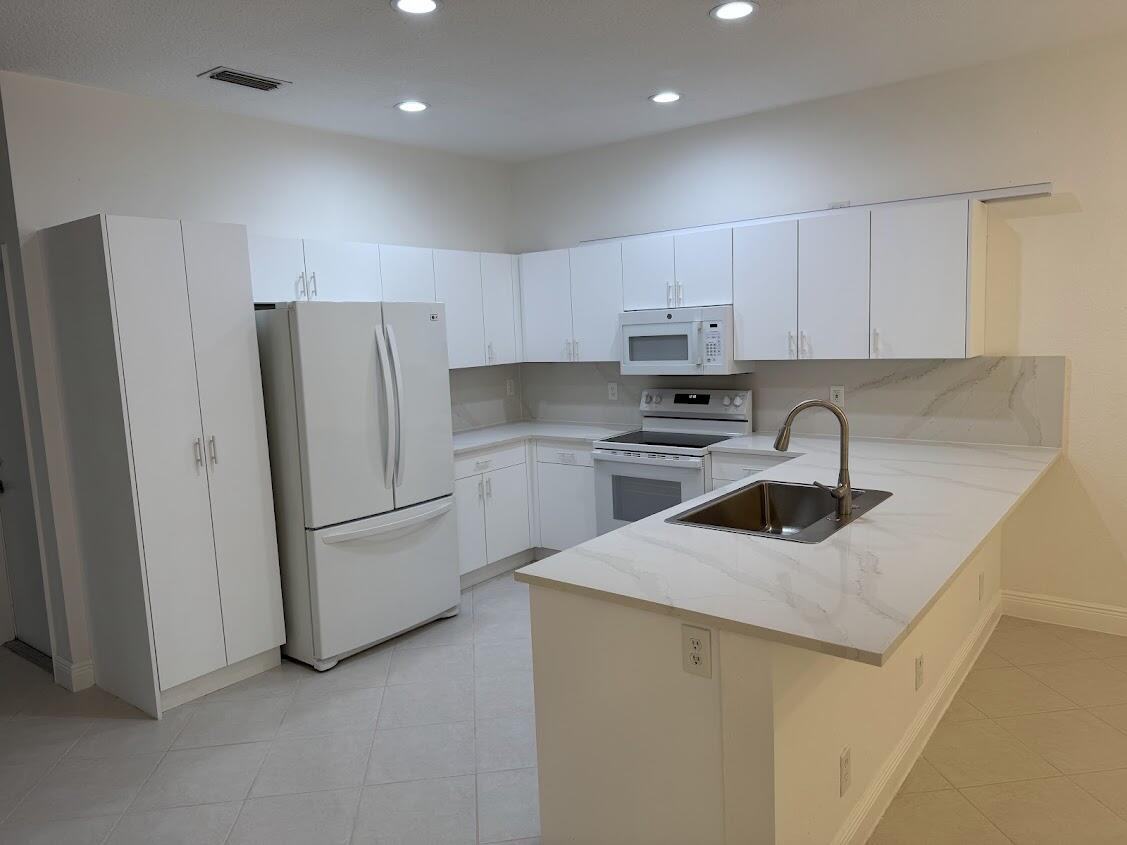 a kitchen with a refrigerator sink and cabinets