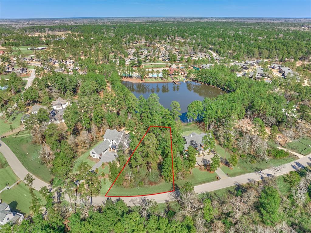 an aerial view of residential houses with outdoor space and trees