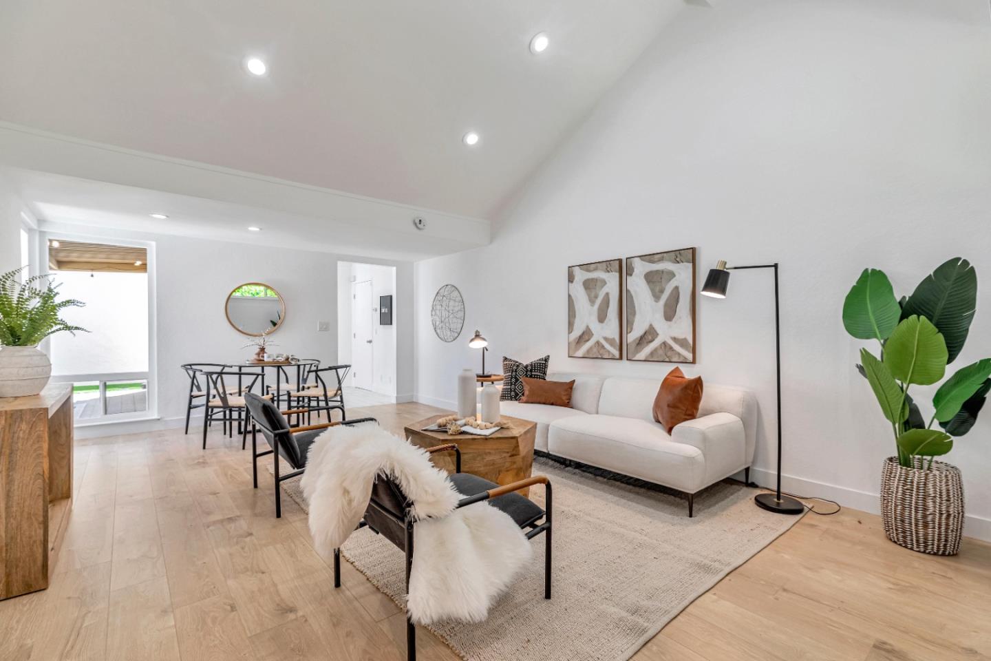 a living room with furniture potted plant and wooden floor