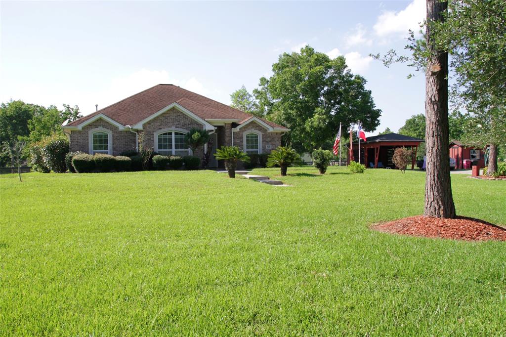 a front view of a house with a yard and trees