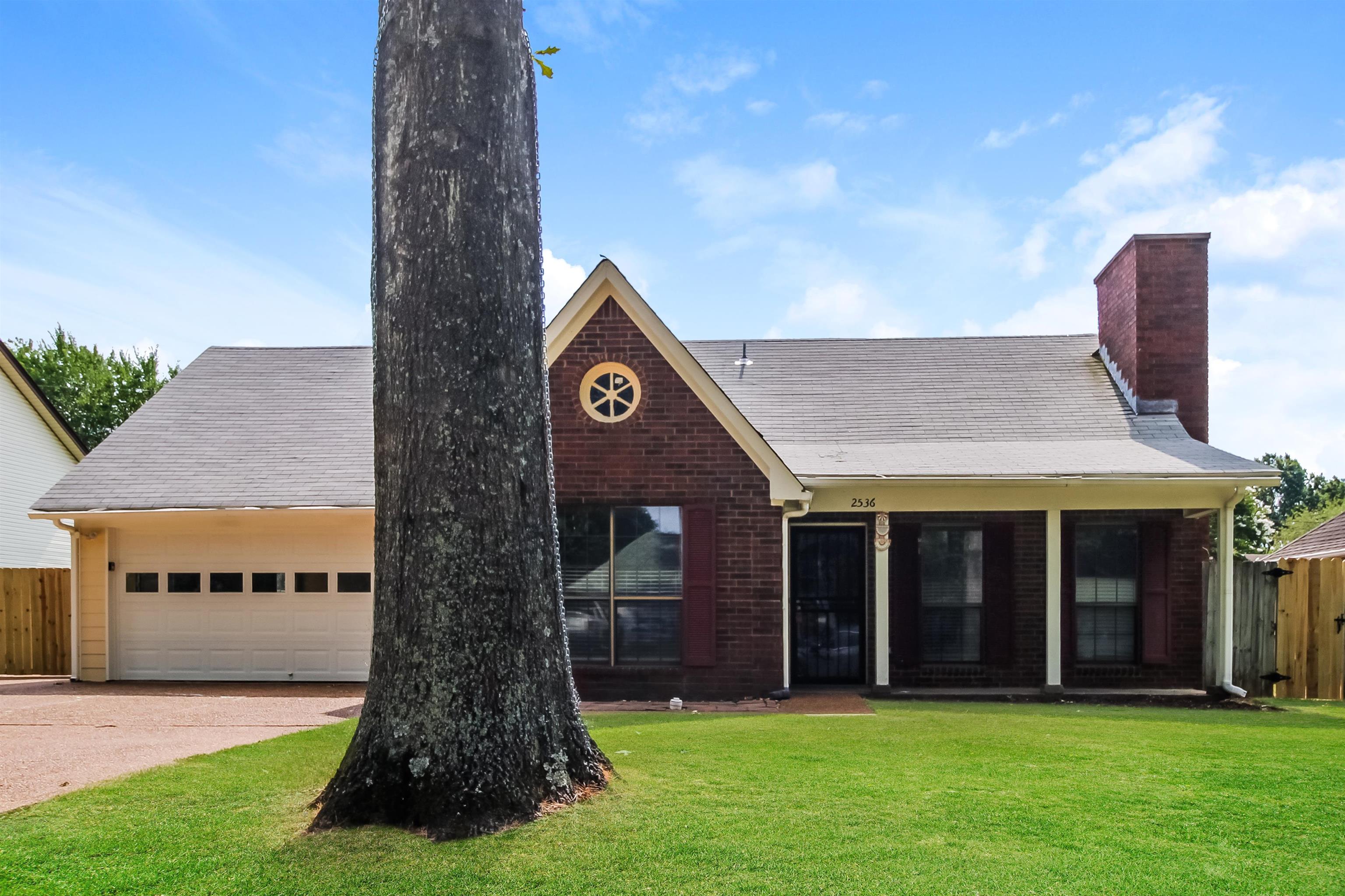 View of front of home with a garage and a front lawn