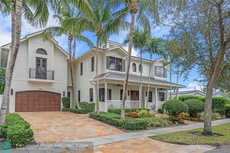 a front view of a house with a yard and palm trees