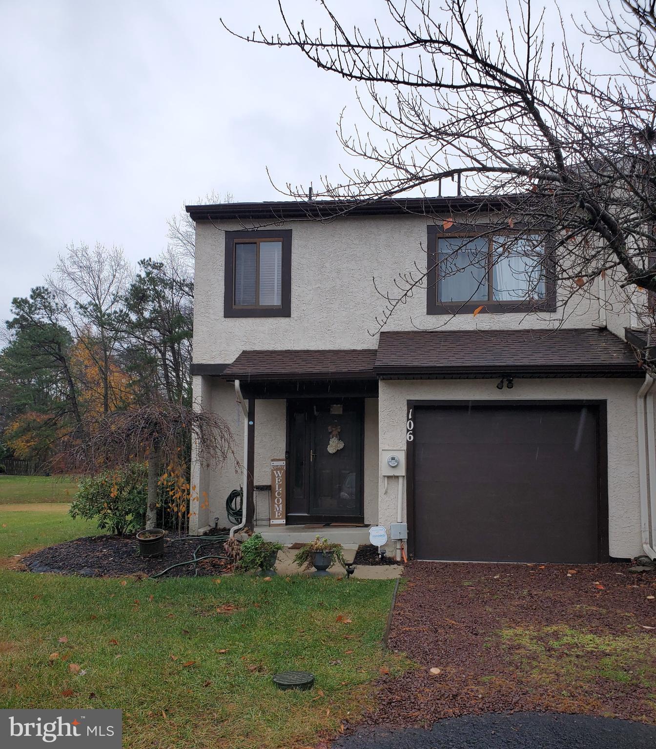 a front view of a house with a garden and garage