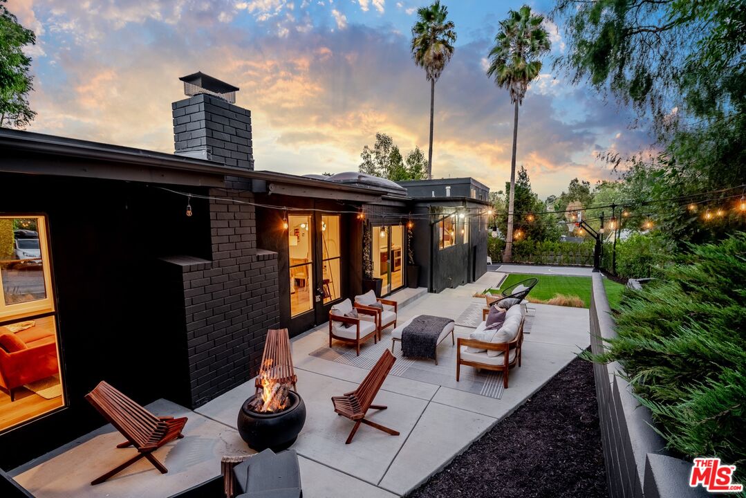 a view of backyard of a house with outdoor seating