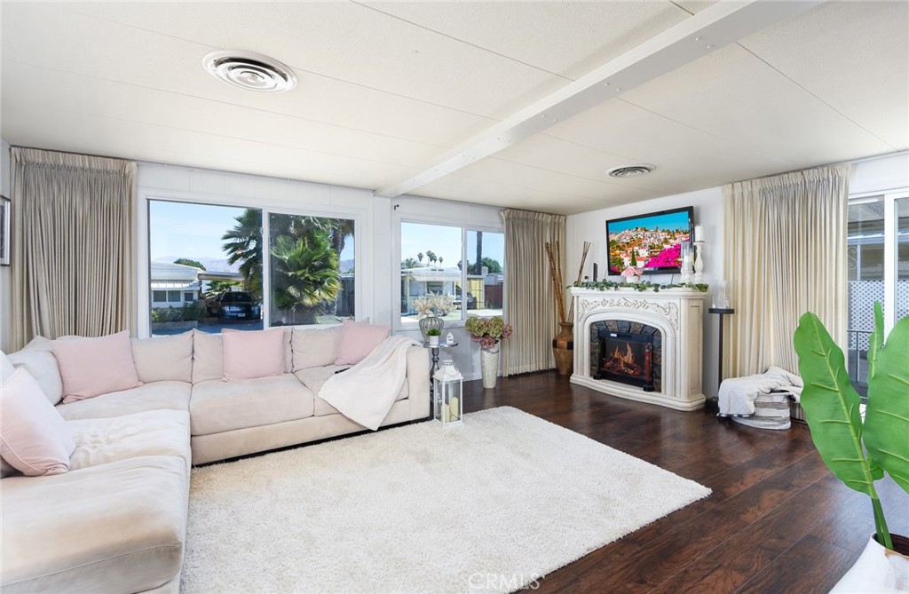 a living room with furniture a flat screen tv and a fireplace