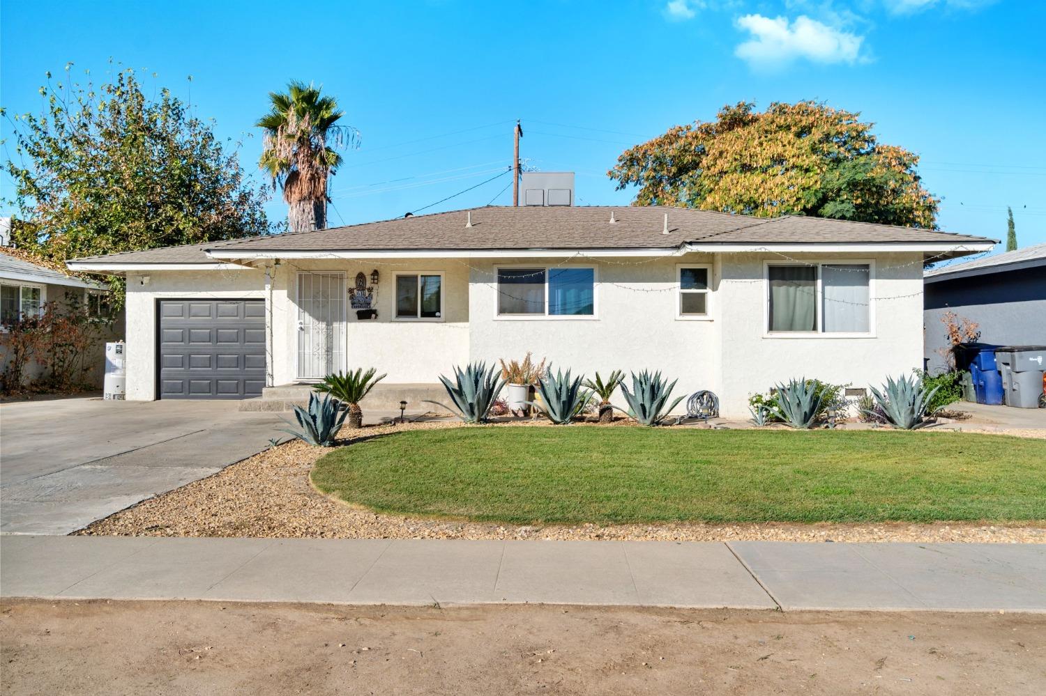 a front view of a house with a garden and yard