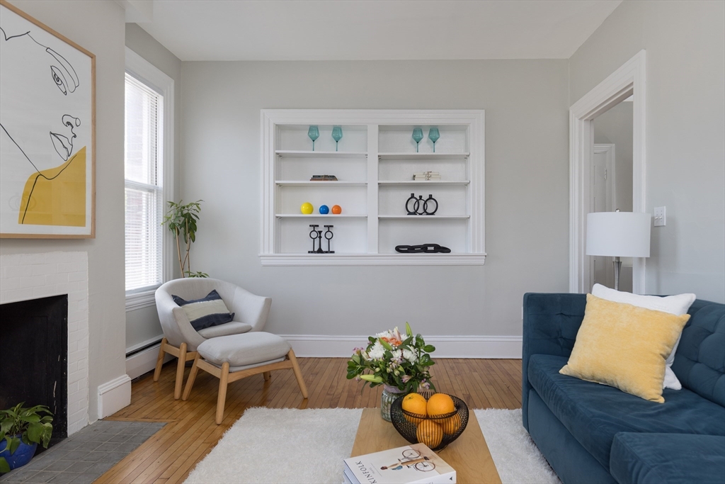 a living room with furniture fireplace and a window