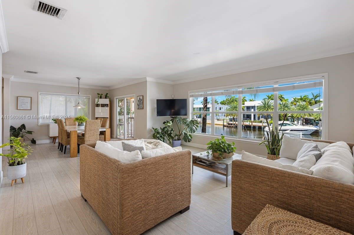 a living room with furniture potted plant and a large window