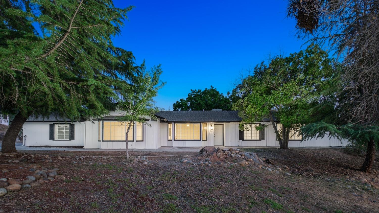 a front view of a house with a tree