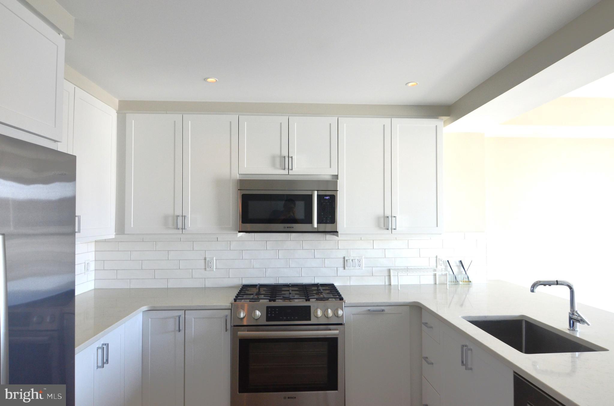 a kitchen with cabinets stainless steel appliances and a sink