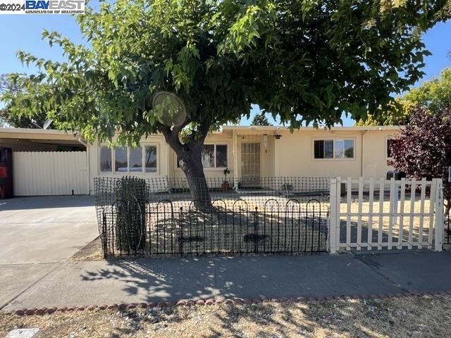 a view of a house with a tree and wooden fence