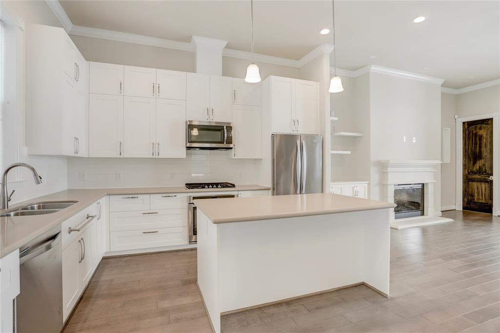 a kitchen with stainless steel appliances kitchen island granite countertop a stove a sink and a refrigerator