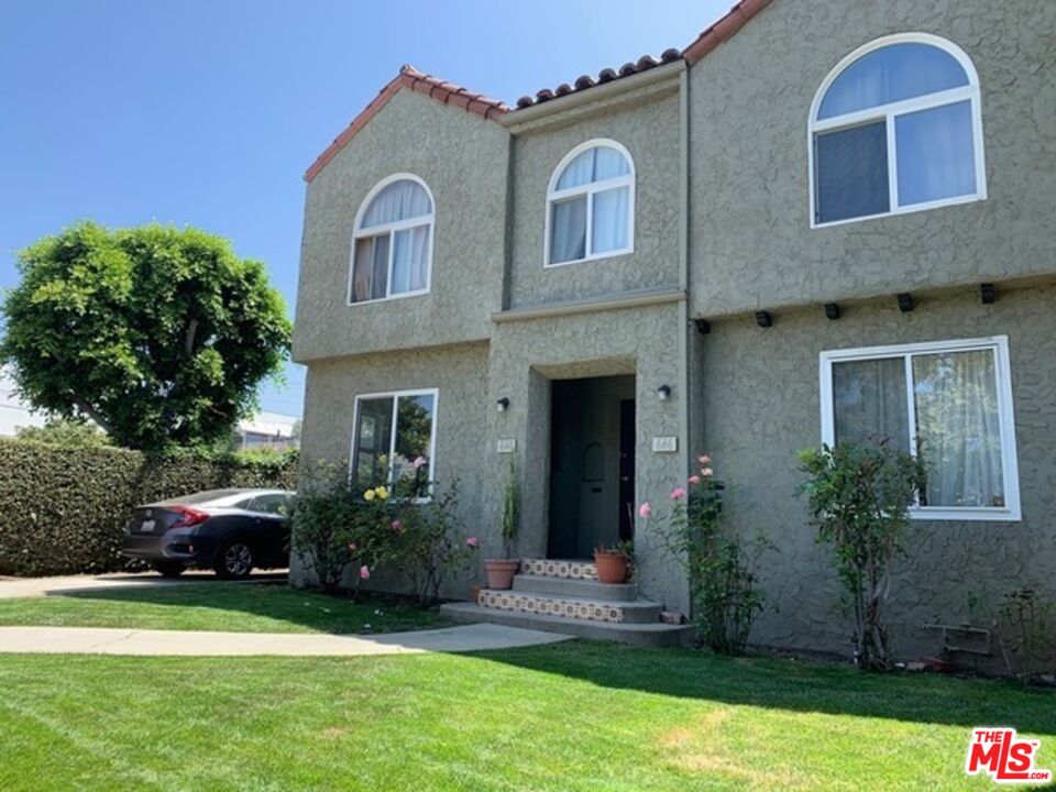 a front view of a house with a garden