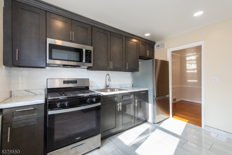 a kitchen with stainless steel appliances granite countertop a stove microwave and refrigerator