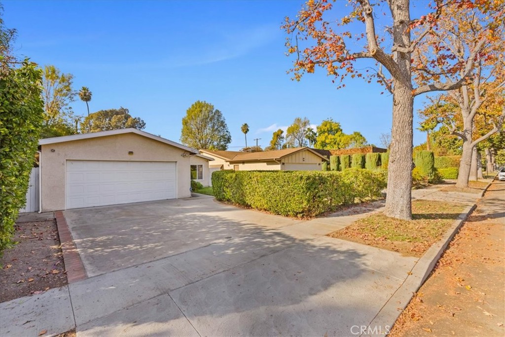 a view of a house with a yard and large tree