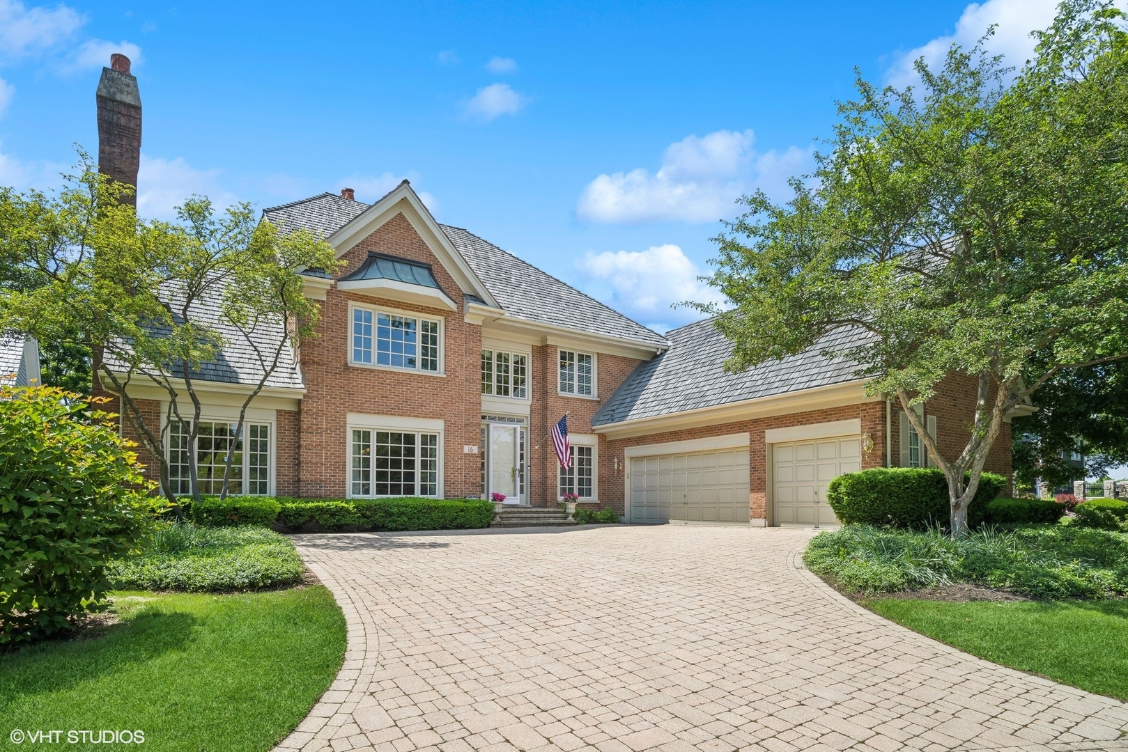 a front view of a house with yard and green space