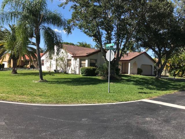 a view of a house with a small yard and palm trees