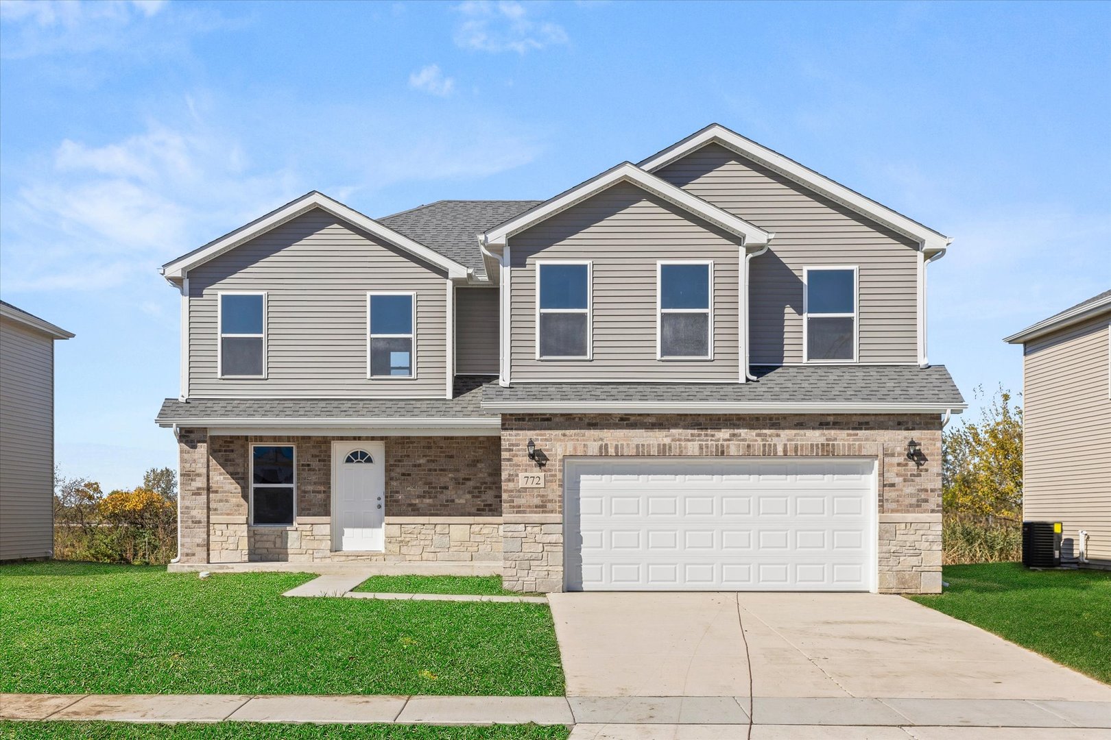 a front view of a house with a yard and garage