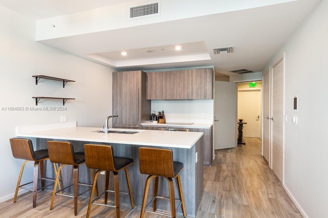 a kitchen with a sink and chairs