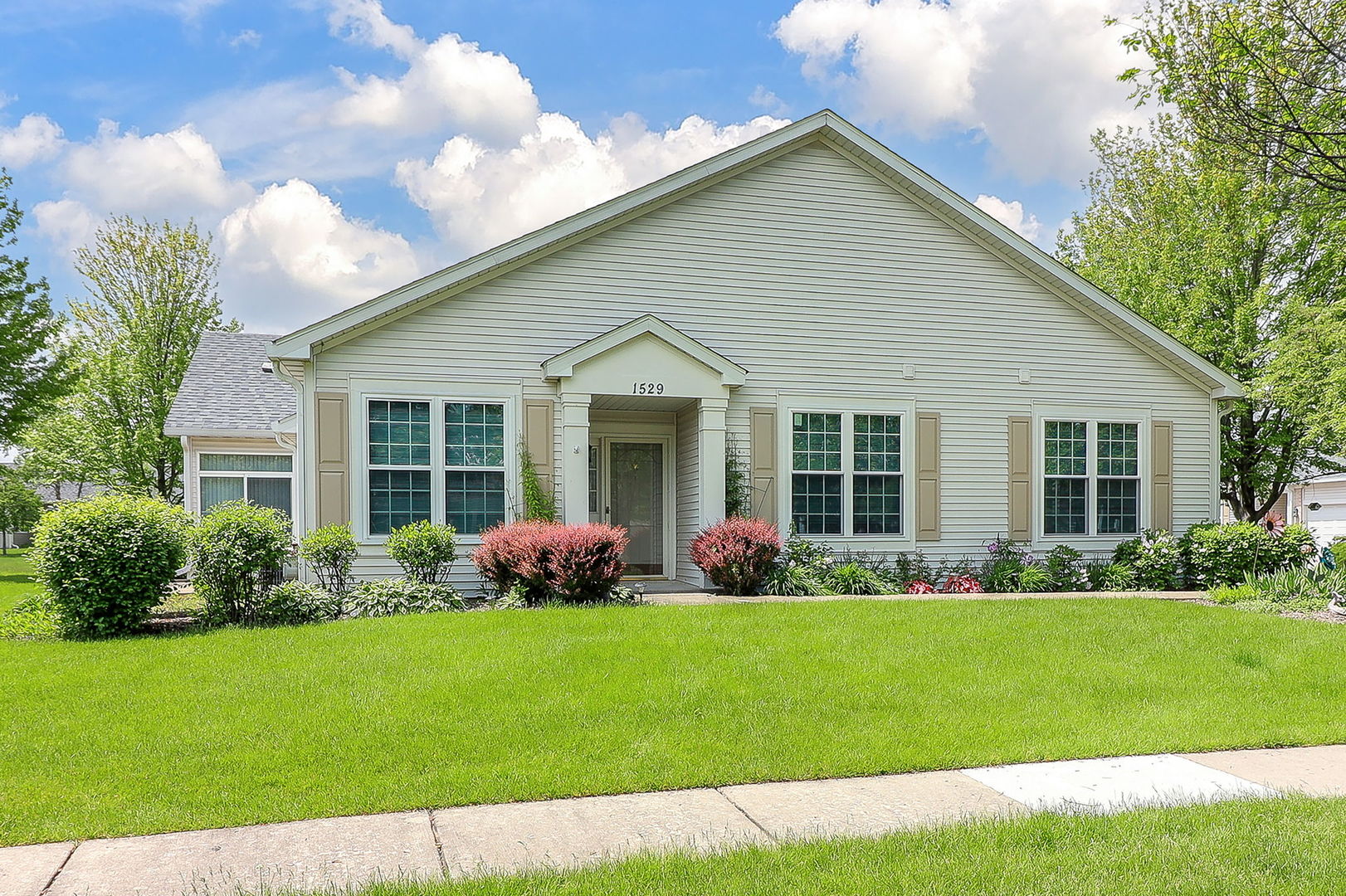 a front view of a house with a garden and plants