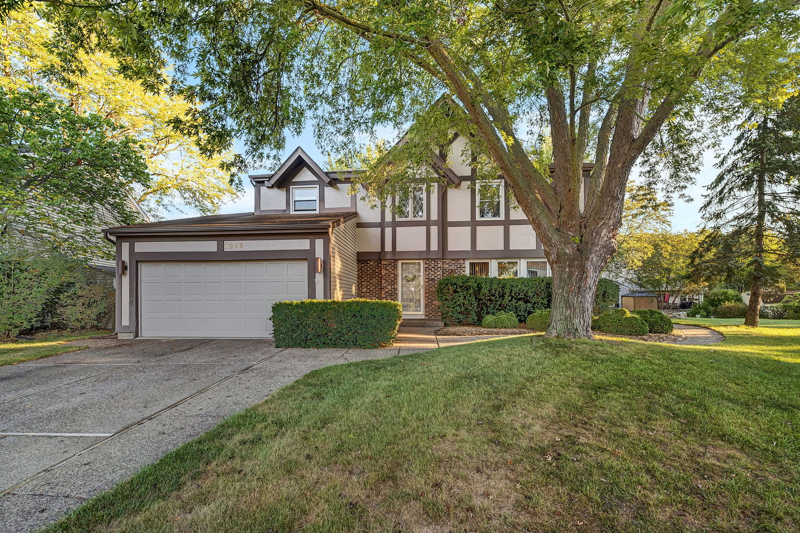 front view of a house with a big yard and large trees