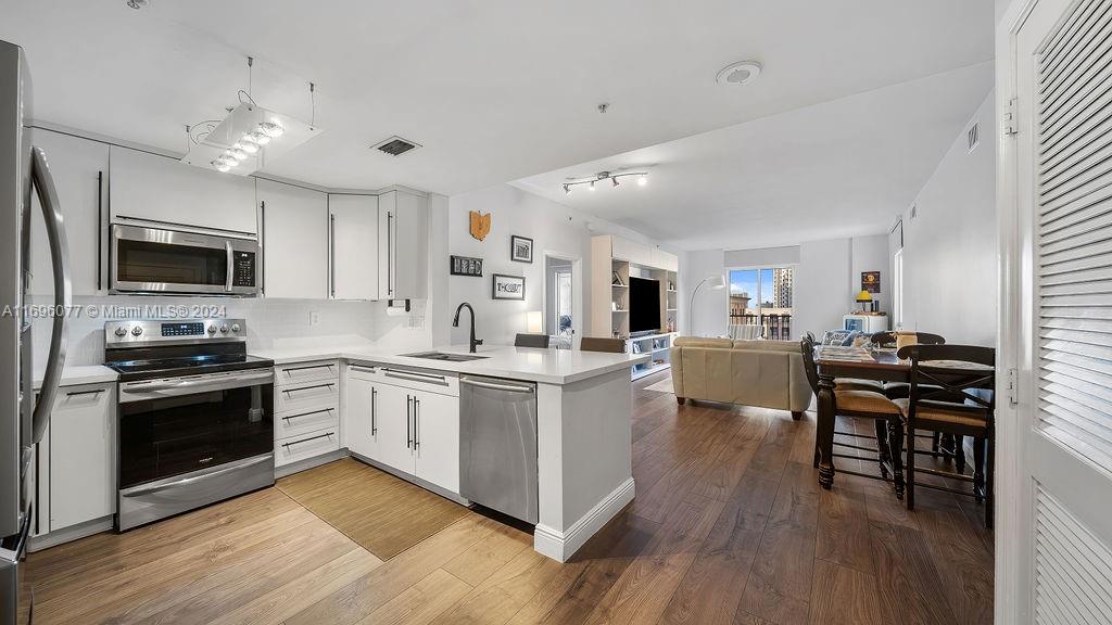 a kitchen with stove a sink and chairs