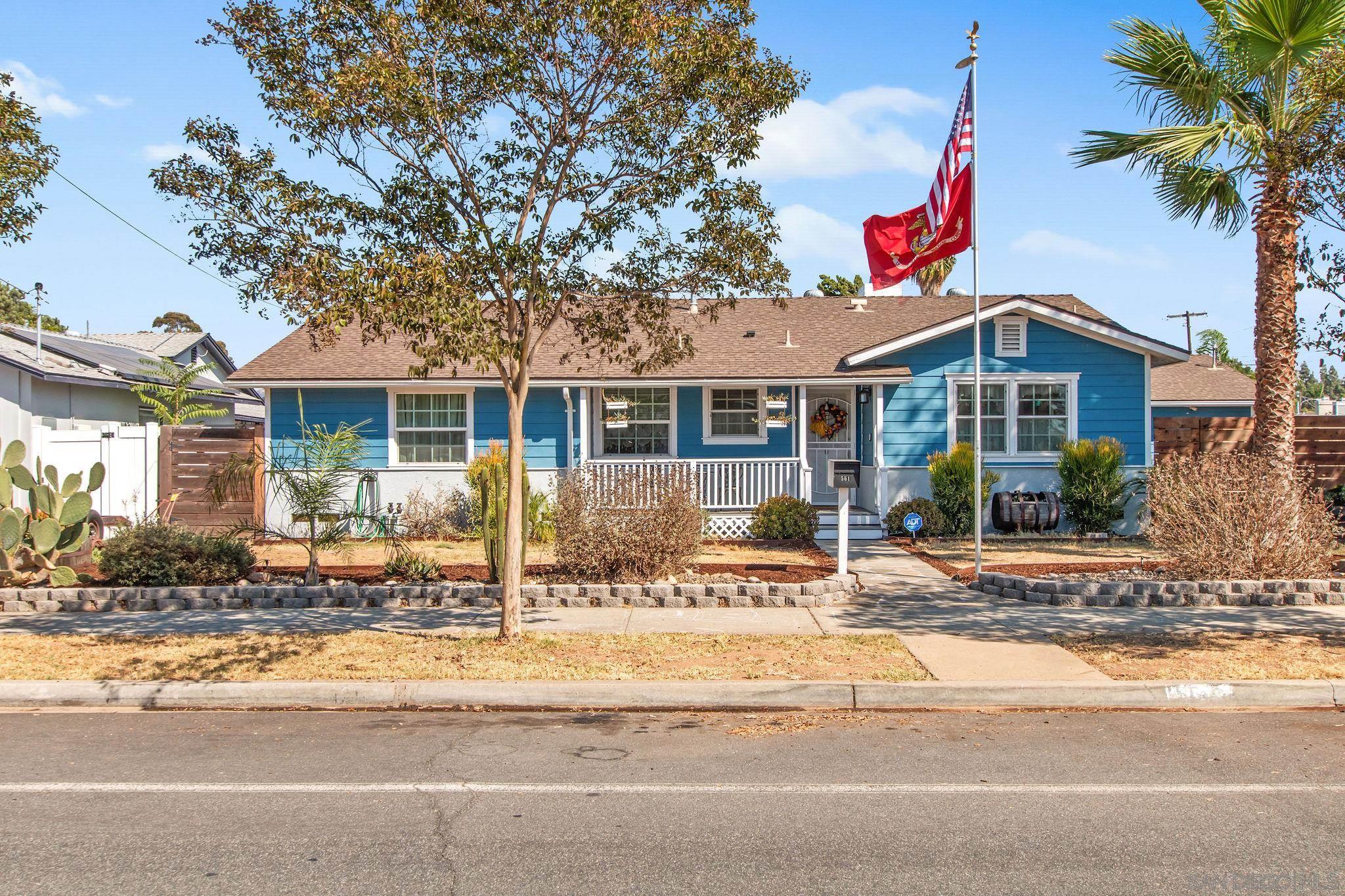 a front view of a house with a yard and potted plants