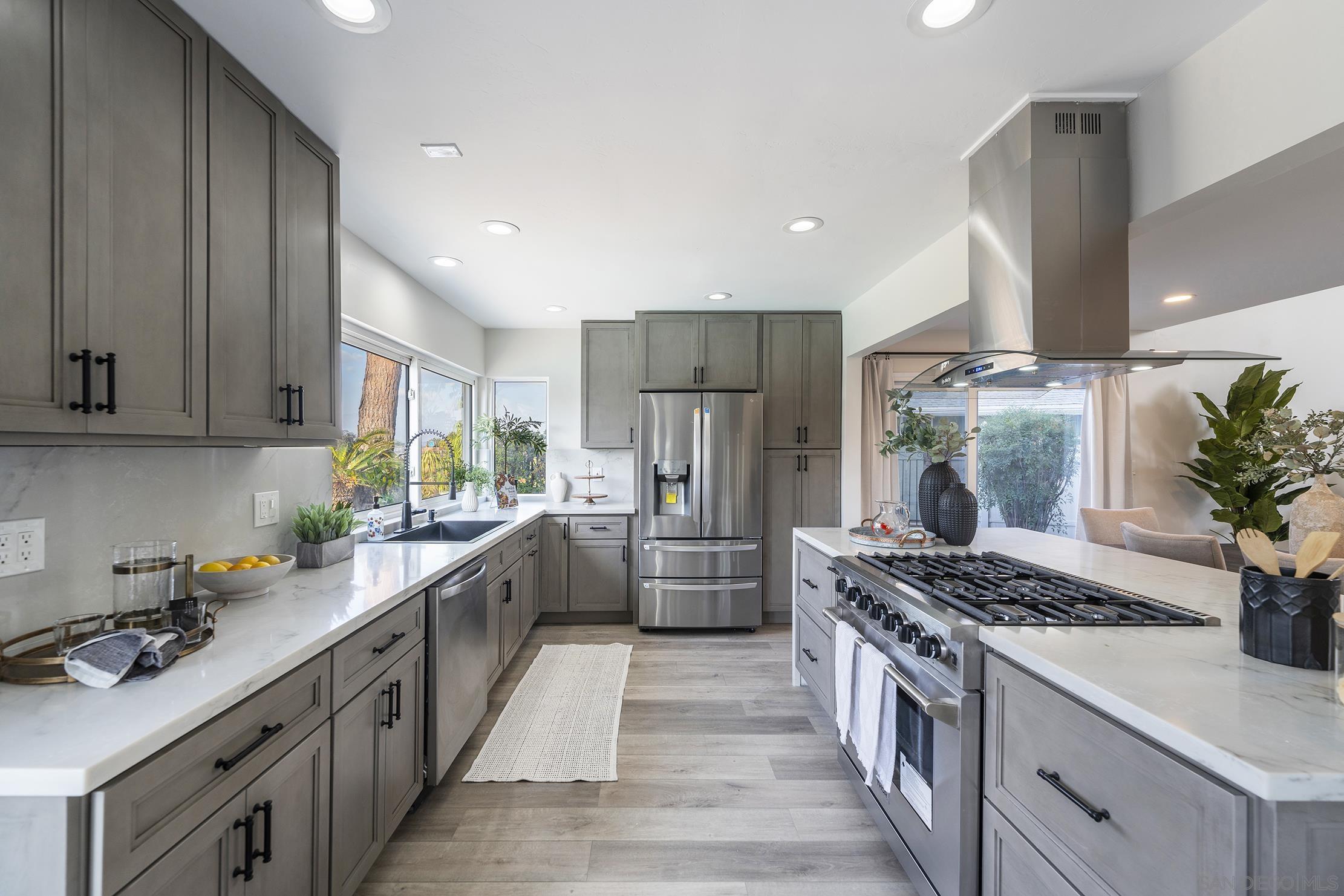 a kitchen with stainless steel appliances kitchen island granite countertop a lot of counter space and wooden floors