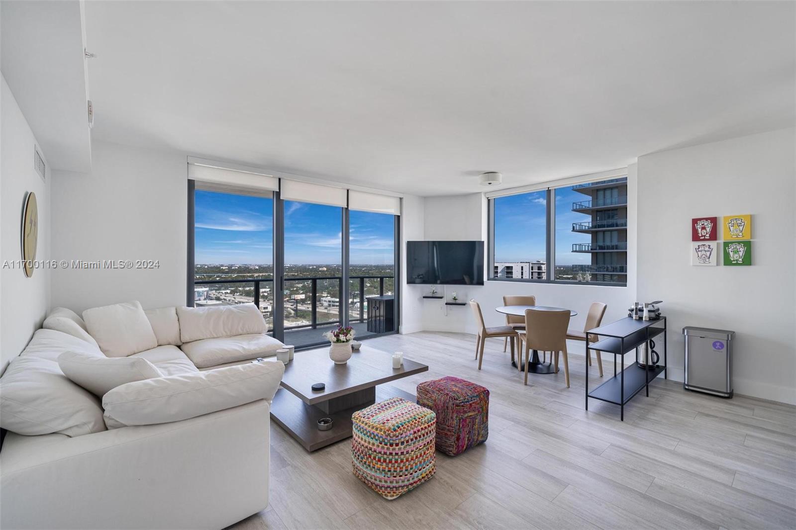 a living room with furniture kitchen view and a large window