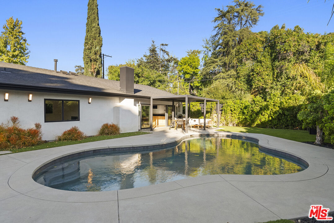 a view of a house with swimming pool and sitting area