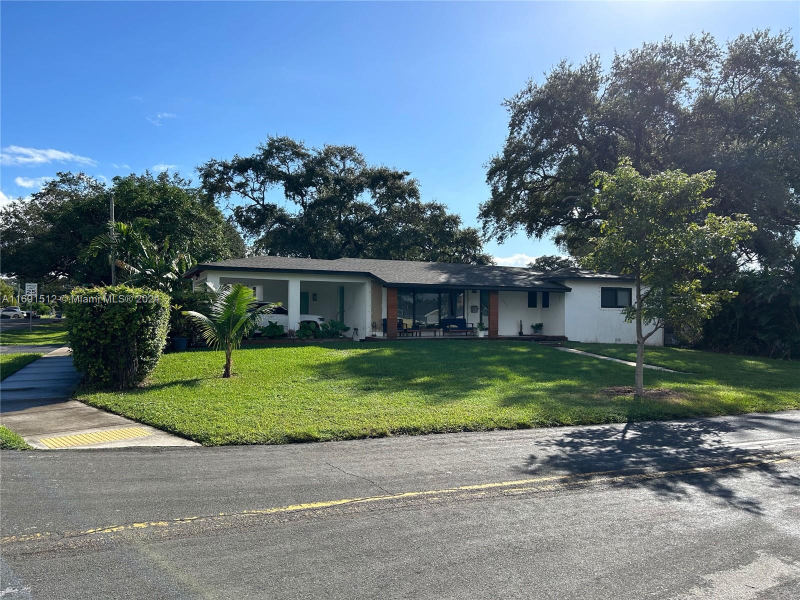 a front view of a house with a yard and trees