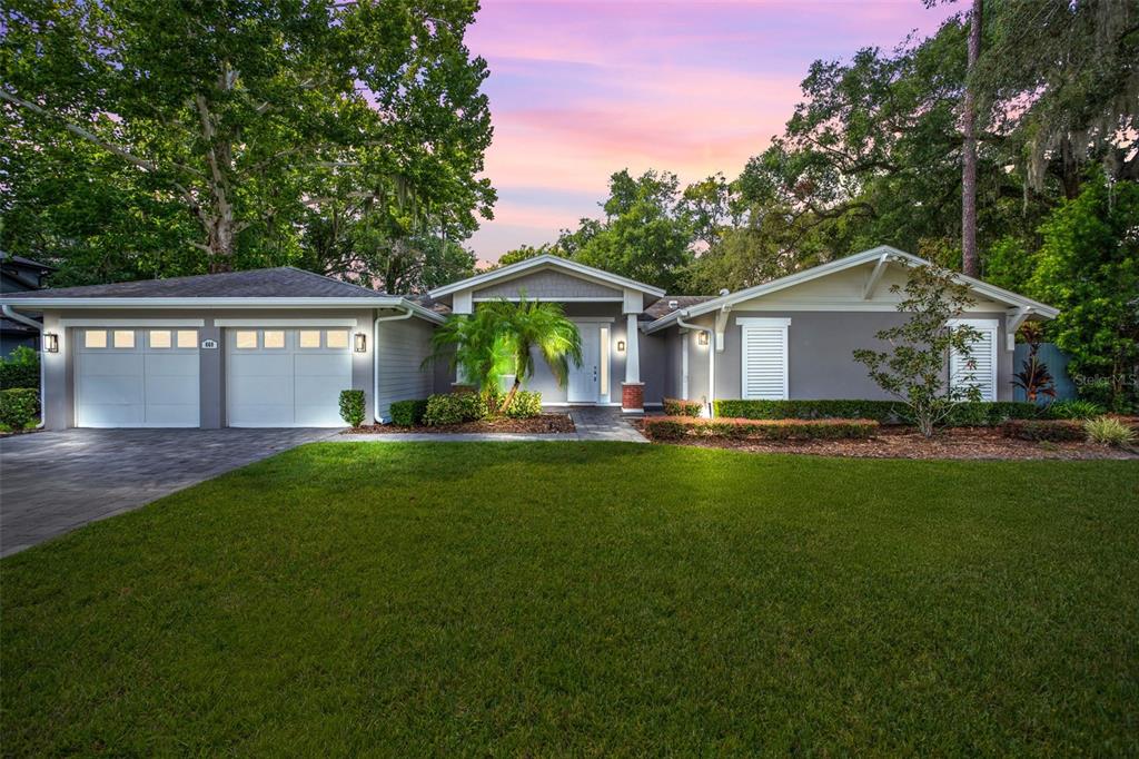 a front view of a house with a yard and green space