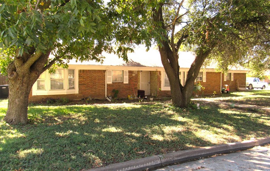 a view of a yard in front of a house with large tree