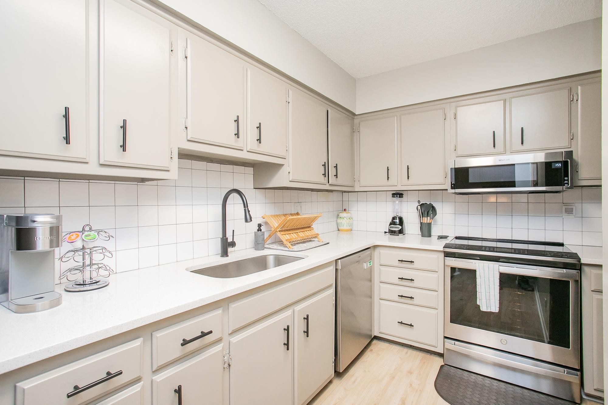 a kitchen with cabinets stainless steel appliances and a sink