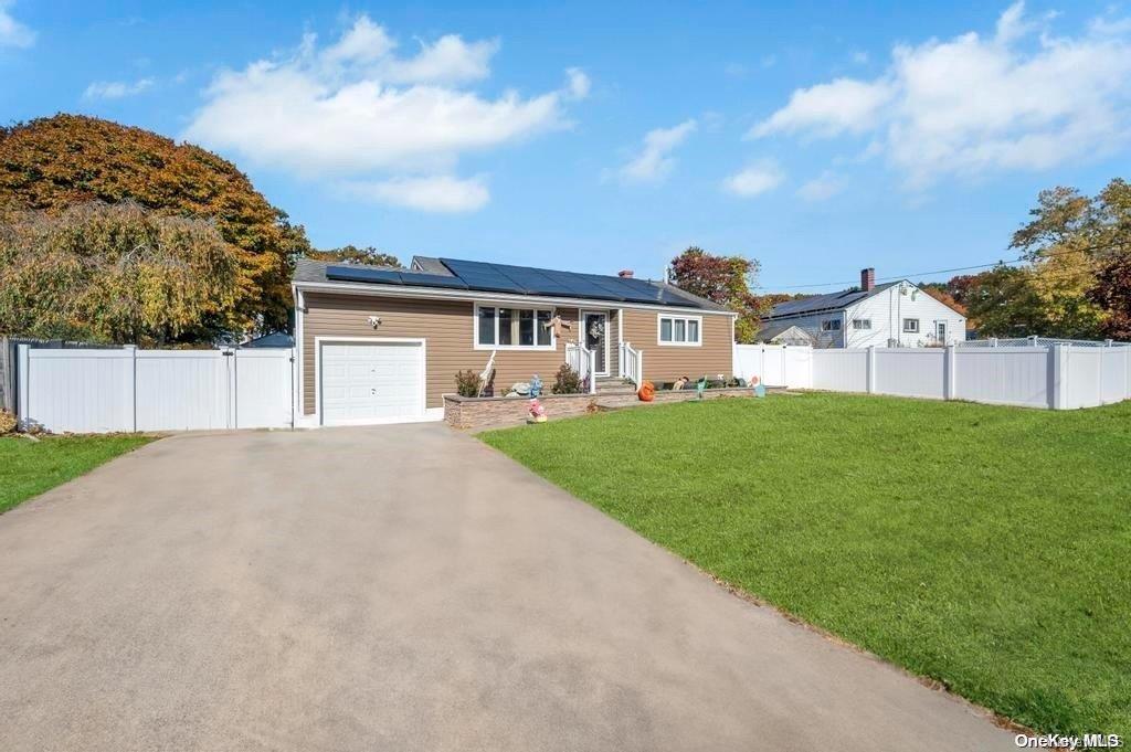 a view of an house with backyard and a tree