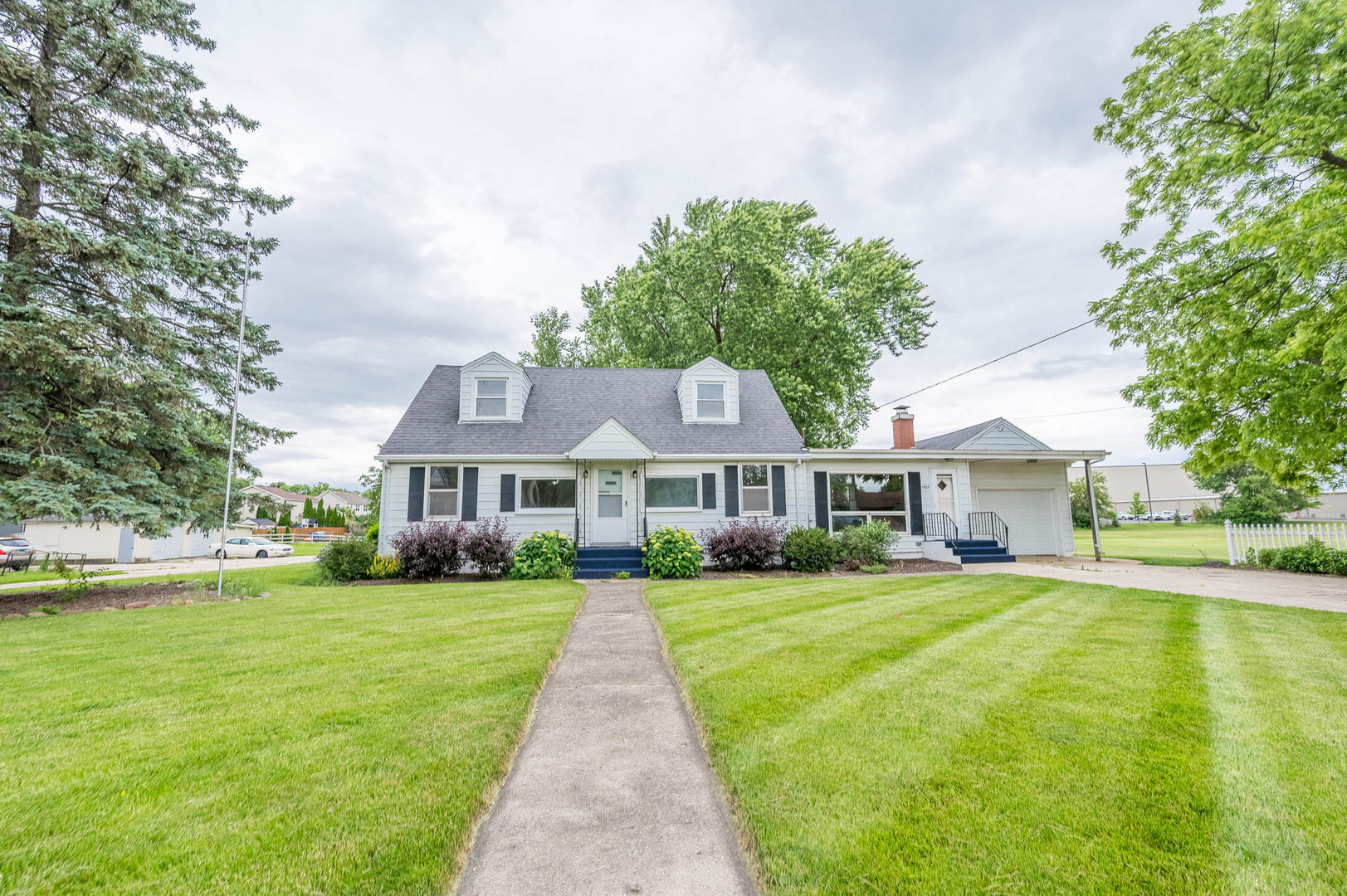 a front view of a house with a yard and trees